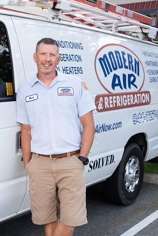 ModernAirNow Serviceman Mark smiling leaning against his truck