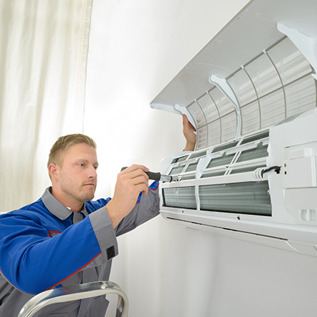 man adjusting and repairing air conditioner unit